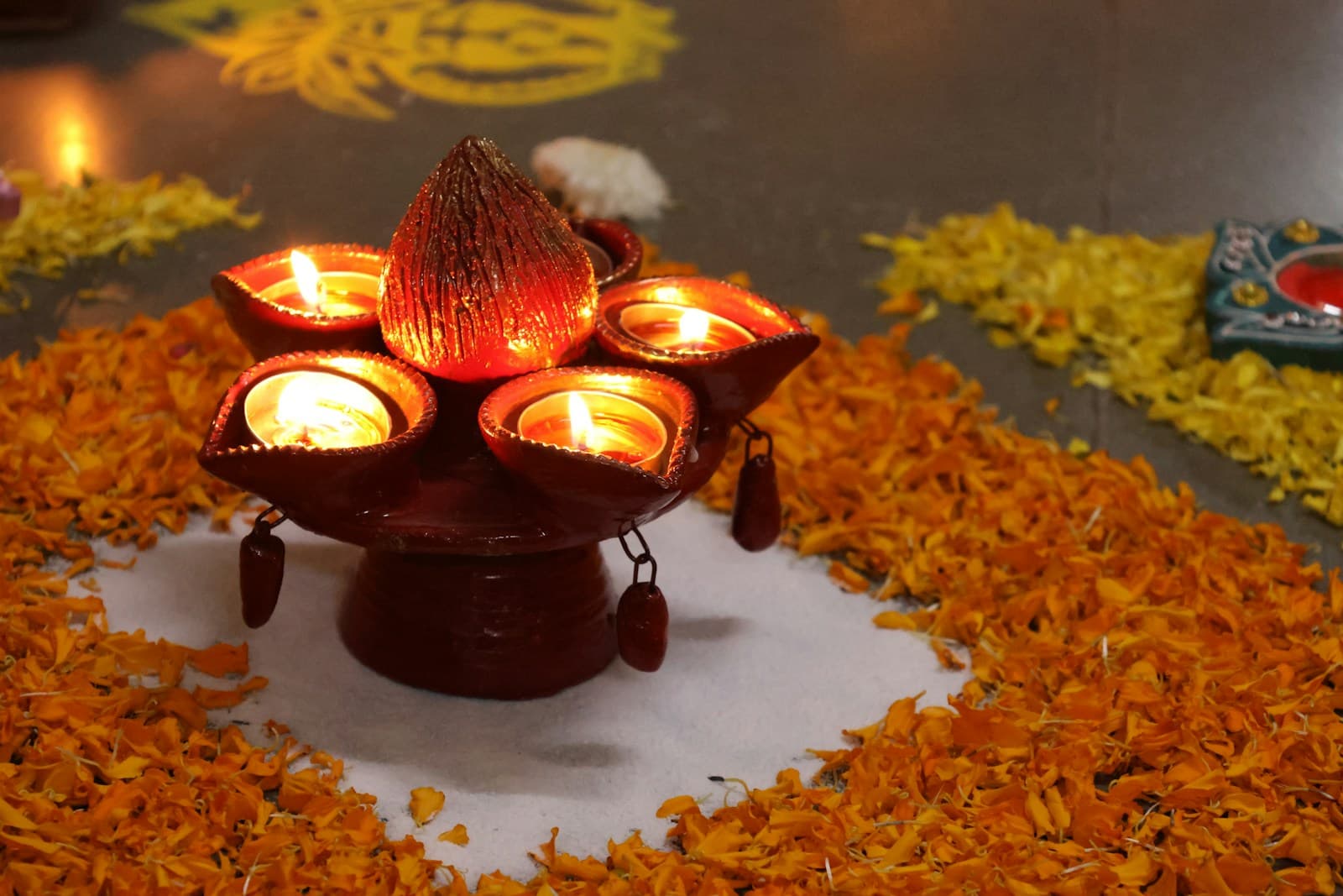Ceremonial clay diyas glowing amid marigold petals and rangoli for an elegant celebration
